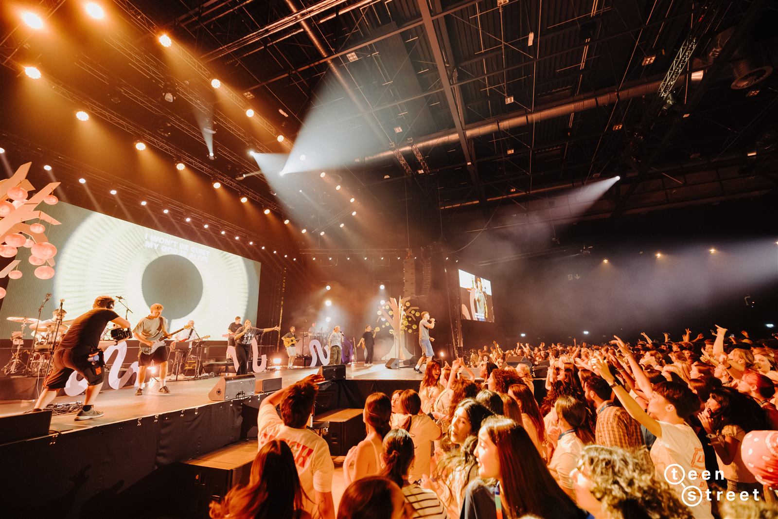 Banda a tocar ao vivo no palco do TeenStreet Europa, com a multidão a cantar